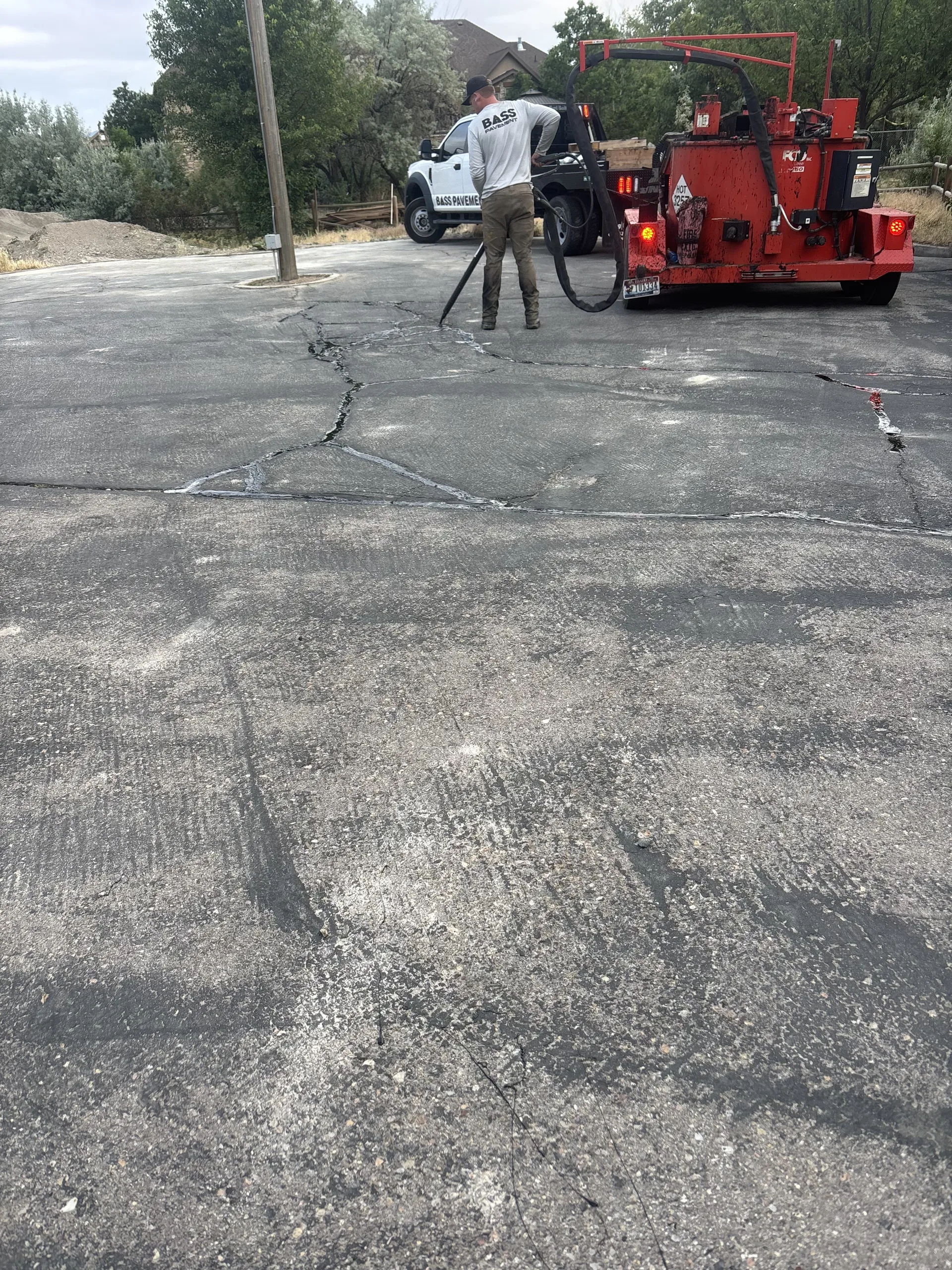 Crew performing hot-applied crack sealing on a driveway